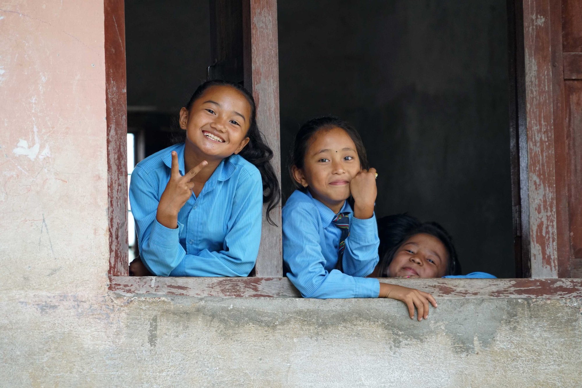 Twee meisjes uit Nepal lachen naar de camera.