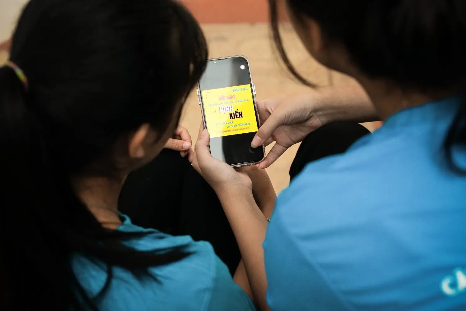 In Vietnam gebruiken meisjes hun telefoon om een petitie te tekenen tegen desinformatie op het internet.&nbsp;