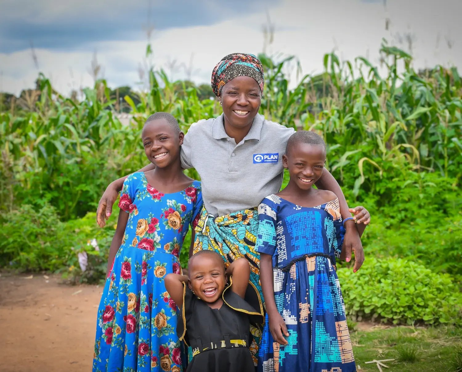 Edwina staat al lachend met haar kinderen voor haar bedrijf. 