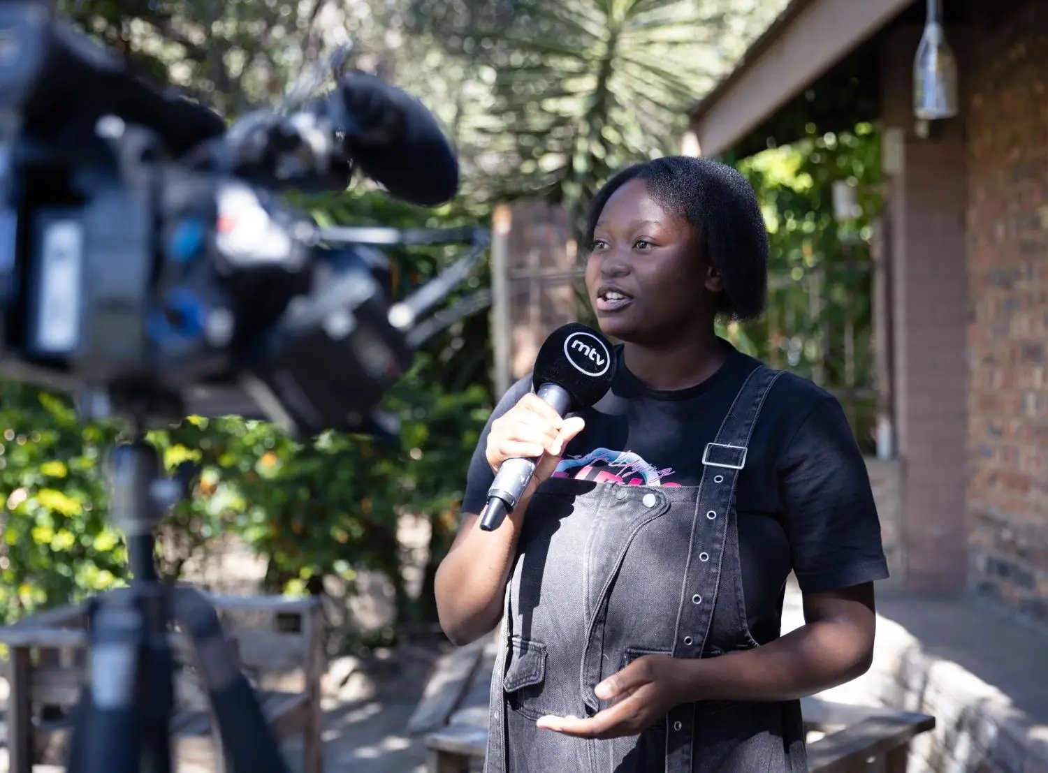 Chantelle tient un micro, face caméra, pour un podcast de sensibilisation. 