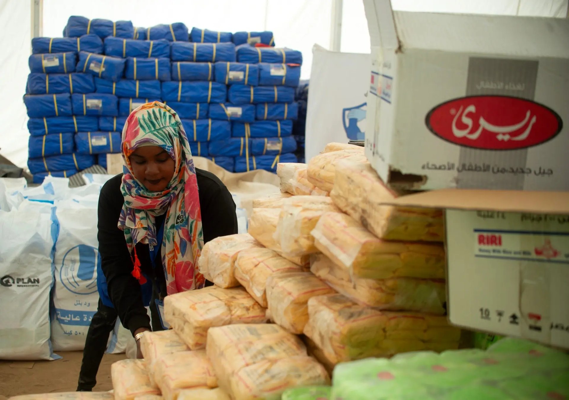 Hulpberleners bereiden voedselhulp voor voor distributie aan ontheemde families in Soedan. 