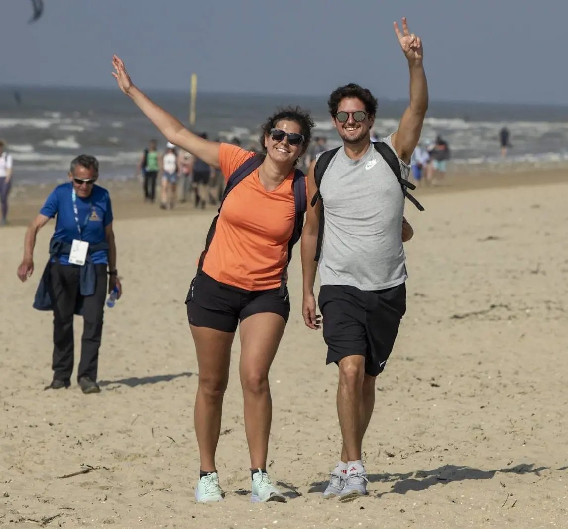 Enthousiaste wandelaars op het strand tijdens de Belgian Coast Walk