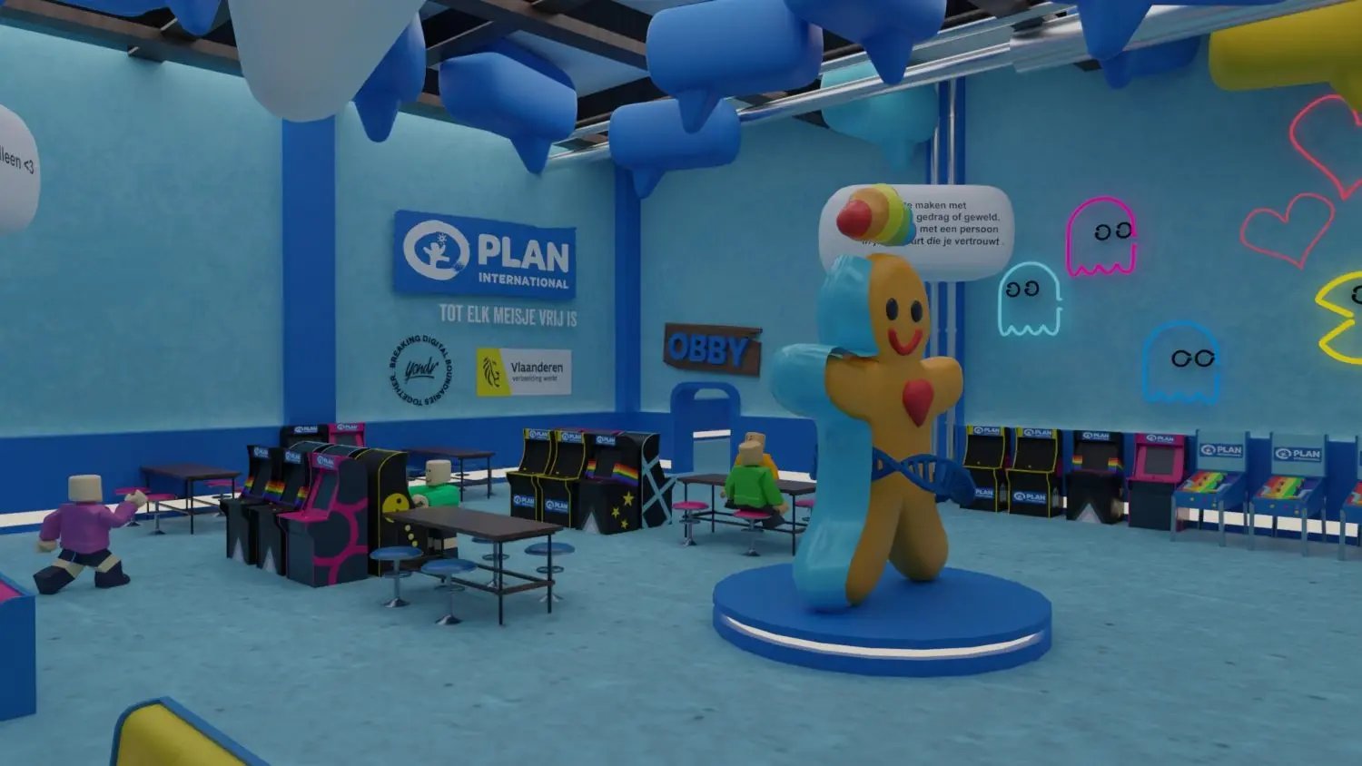 Een blauwe kamer met een groot "genderkoek"-beeld, arcadekasten en neonversieringen met Pac-Man-achtige spookjes. 