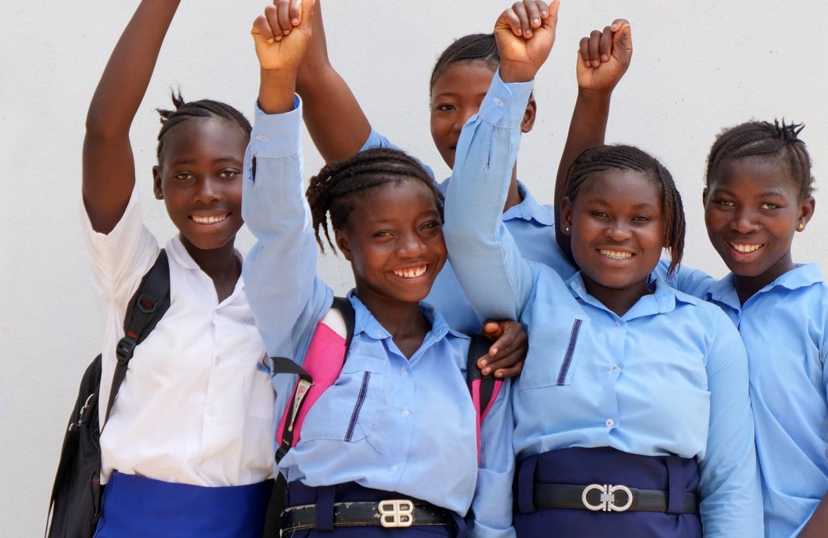 Girls happily raising their fists in the air smiling at the camera