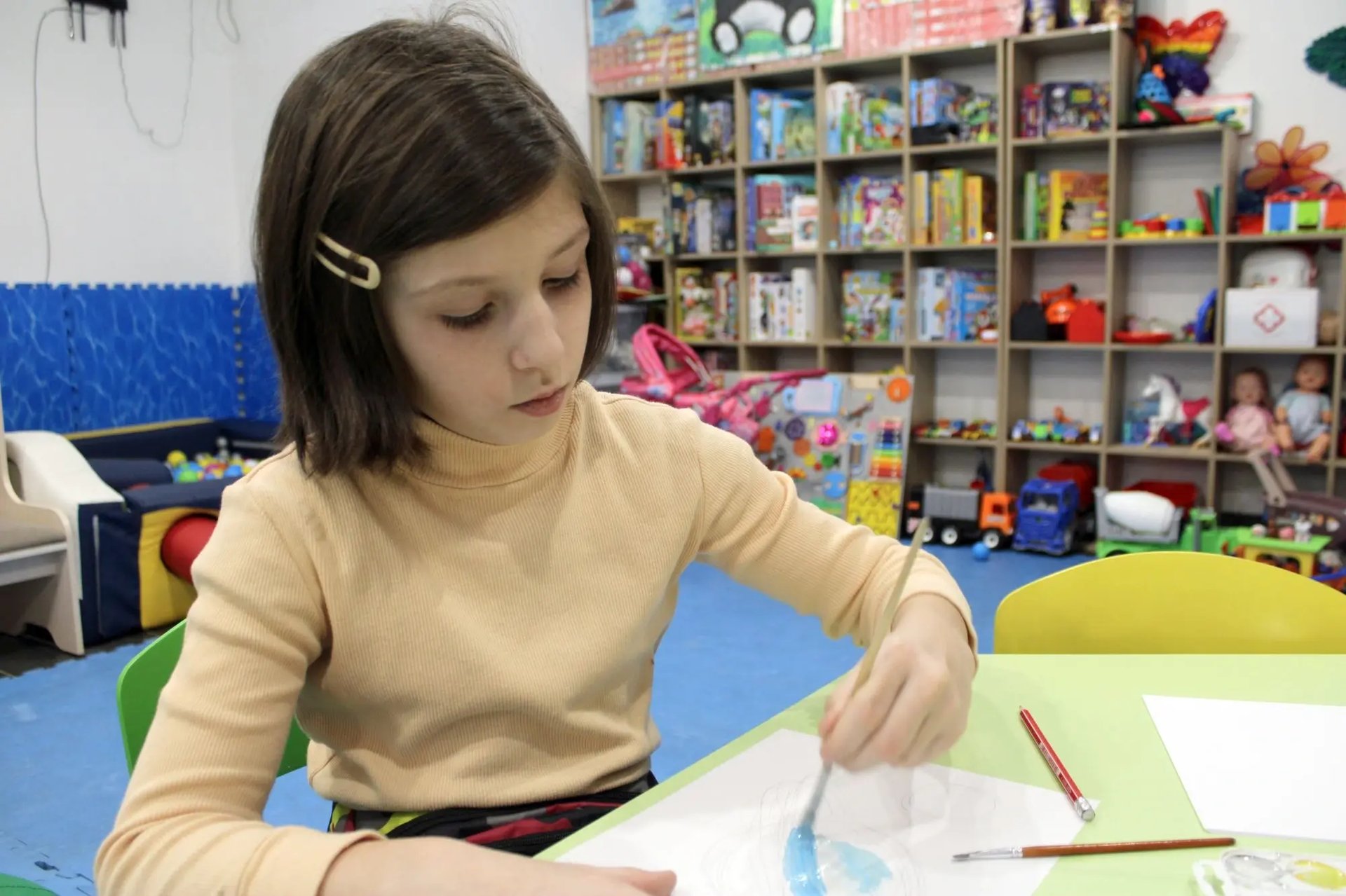 Helga, 9 jaar, aan het tekenen in de veilige leeromgeving voor kinderen waar ze elke dag naartoe gaat in Oekraïne.