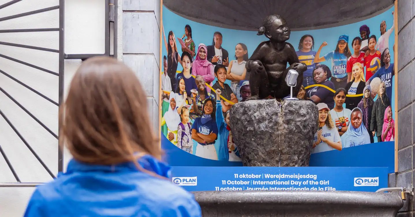 a girl looking at jeanneke pis with plan international branding