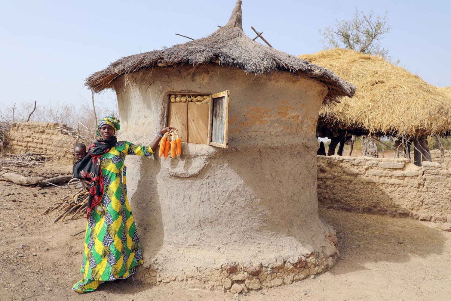 Corn producer Bintou in front of its granary