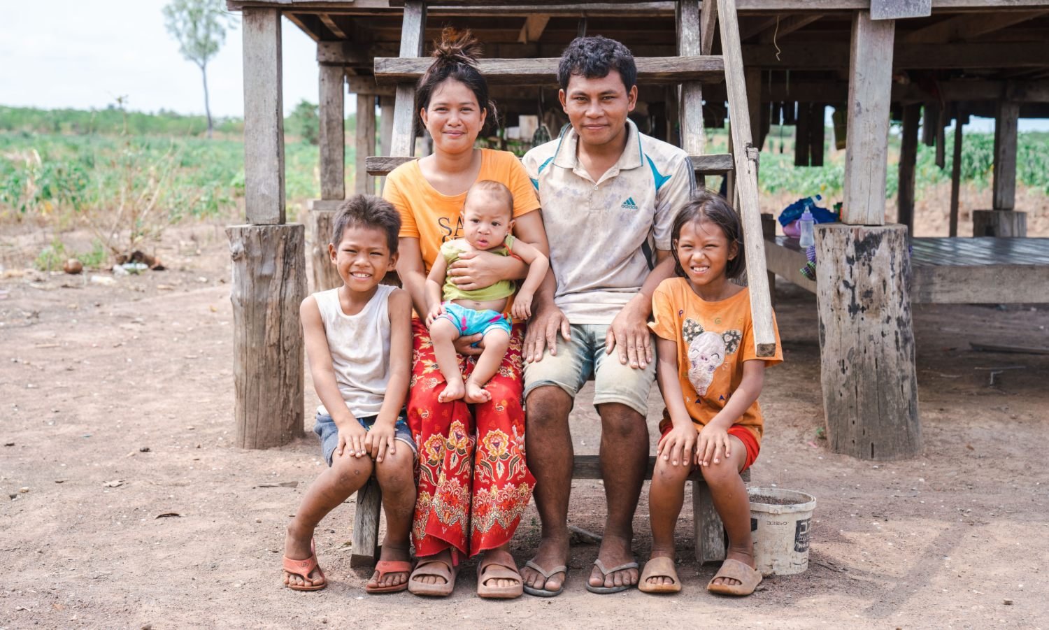 Muta avec ses parents et ses frères assis devant leur maison. 