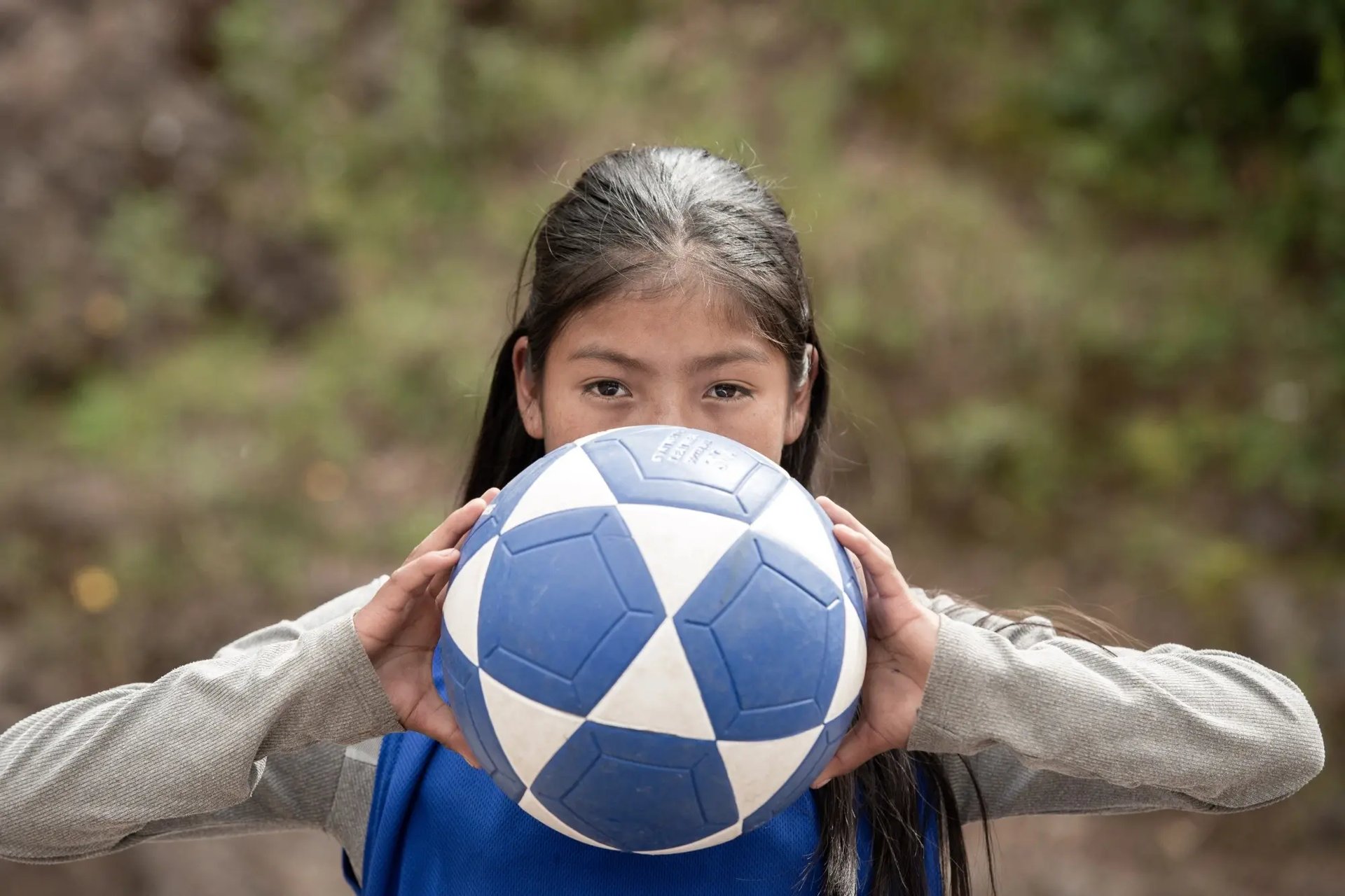 Een Peruaans meisje heeft een bal vast. Ze doet mee aan het project Change the Game, dat voetbal als hefboom inzet in de strijd tegen genderongelijkheid. 