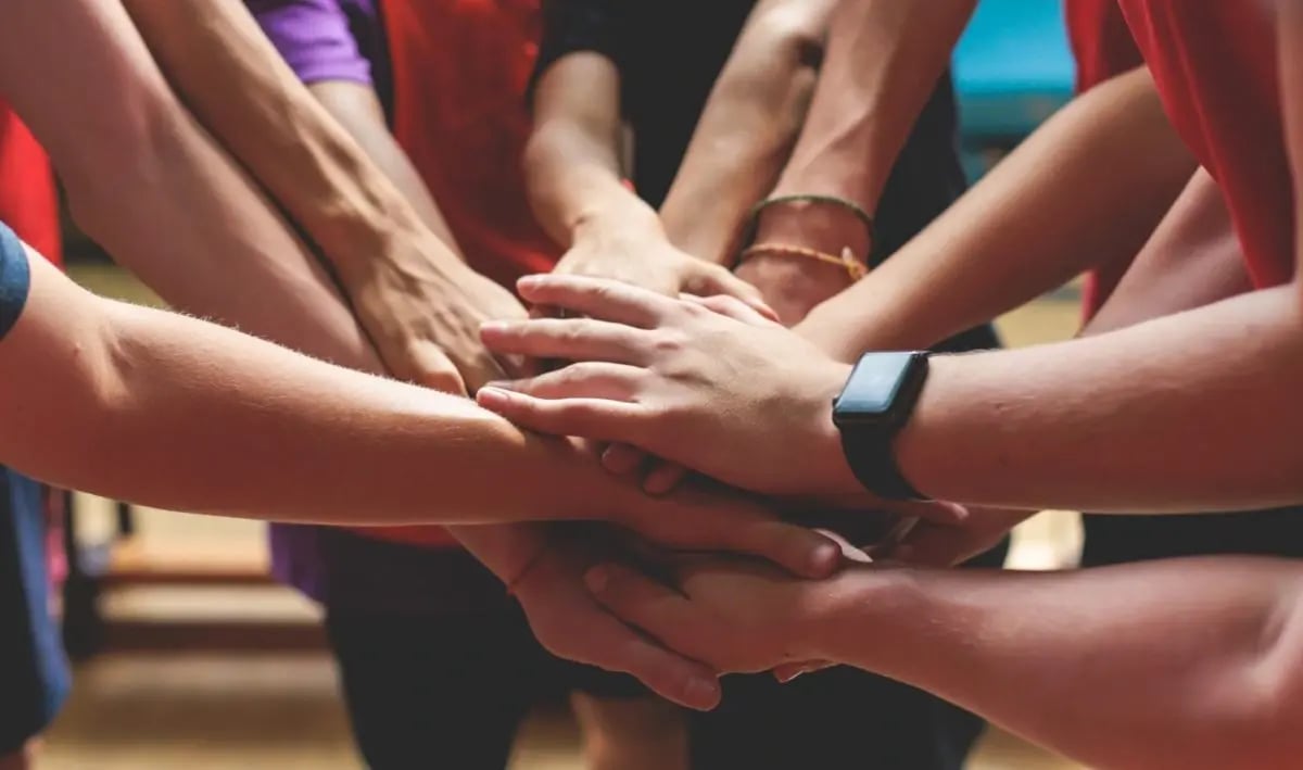 Un groupe de jeunes se tenant les mains ensemble en cercle