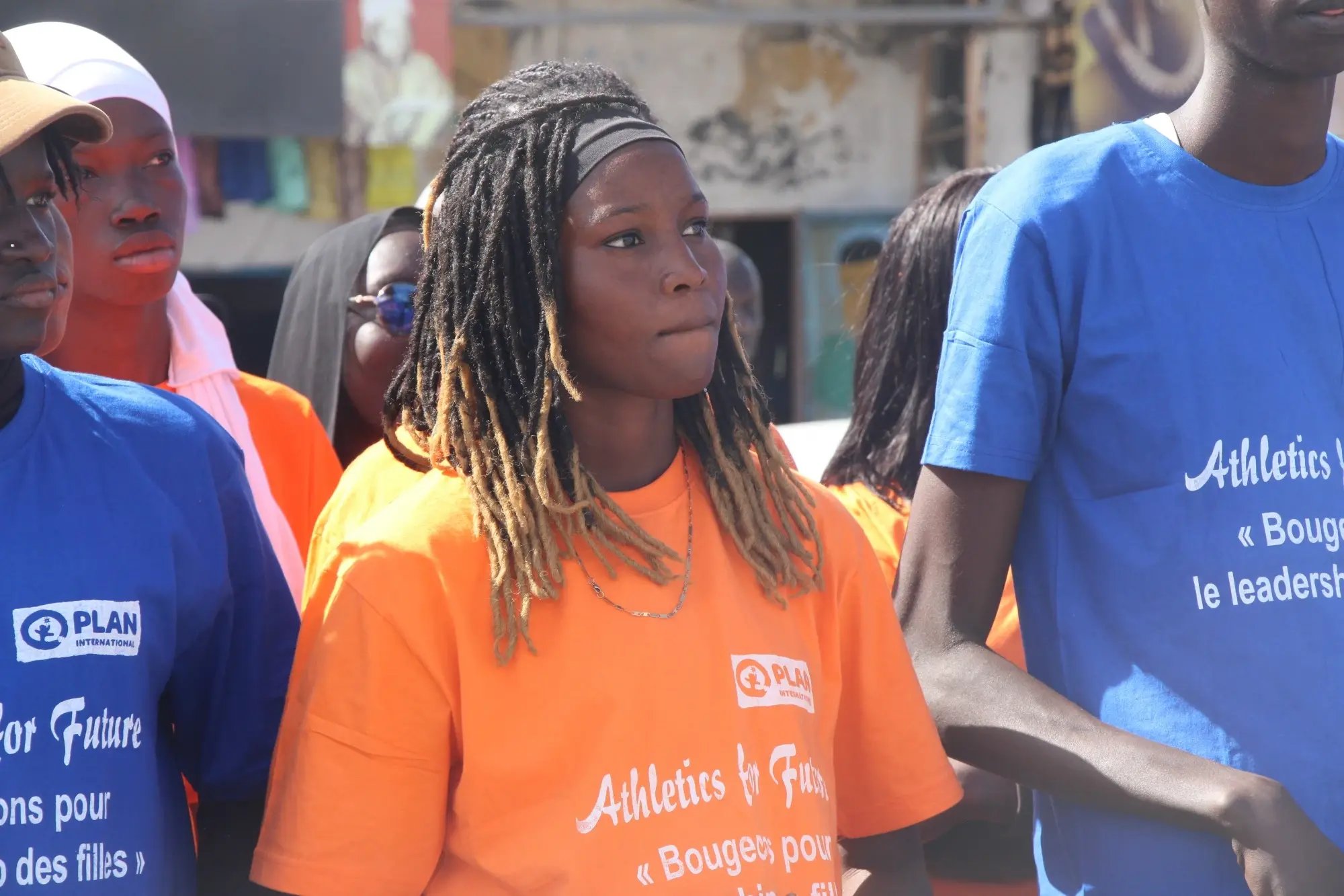 Groep meisjes die deelneemt aan Athletics for Future trekt door de straten met T-shirts van het project.