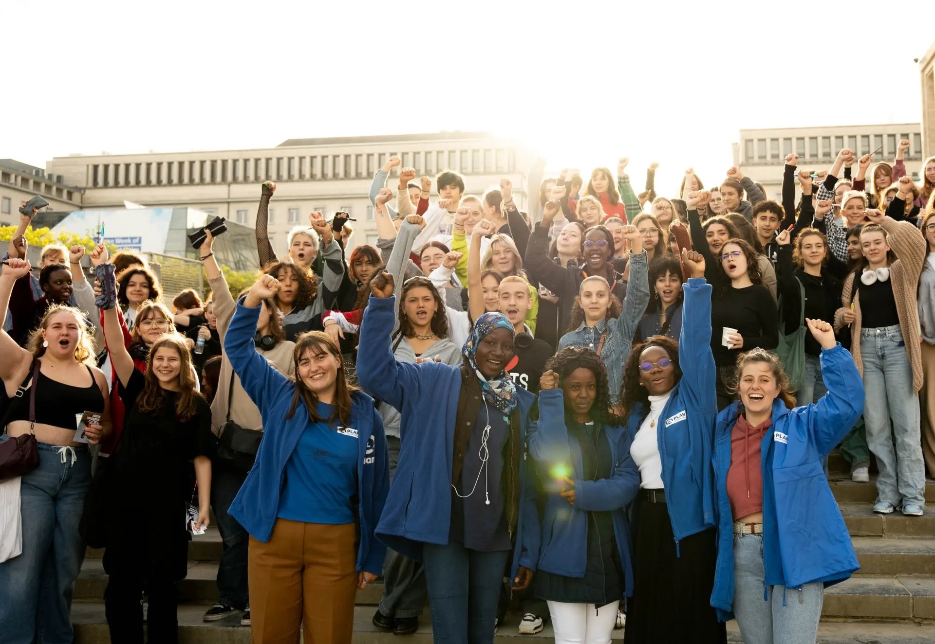 Jonge vrijwilligers op de trappen van de Kunstberg in Brussel doen mee aan een bewustmakingsactie van Plan International België voor onderwijs en gendergelijkheid. 