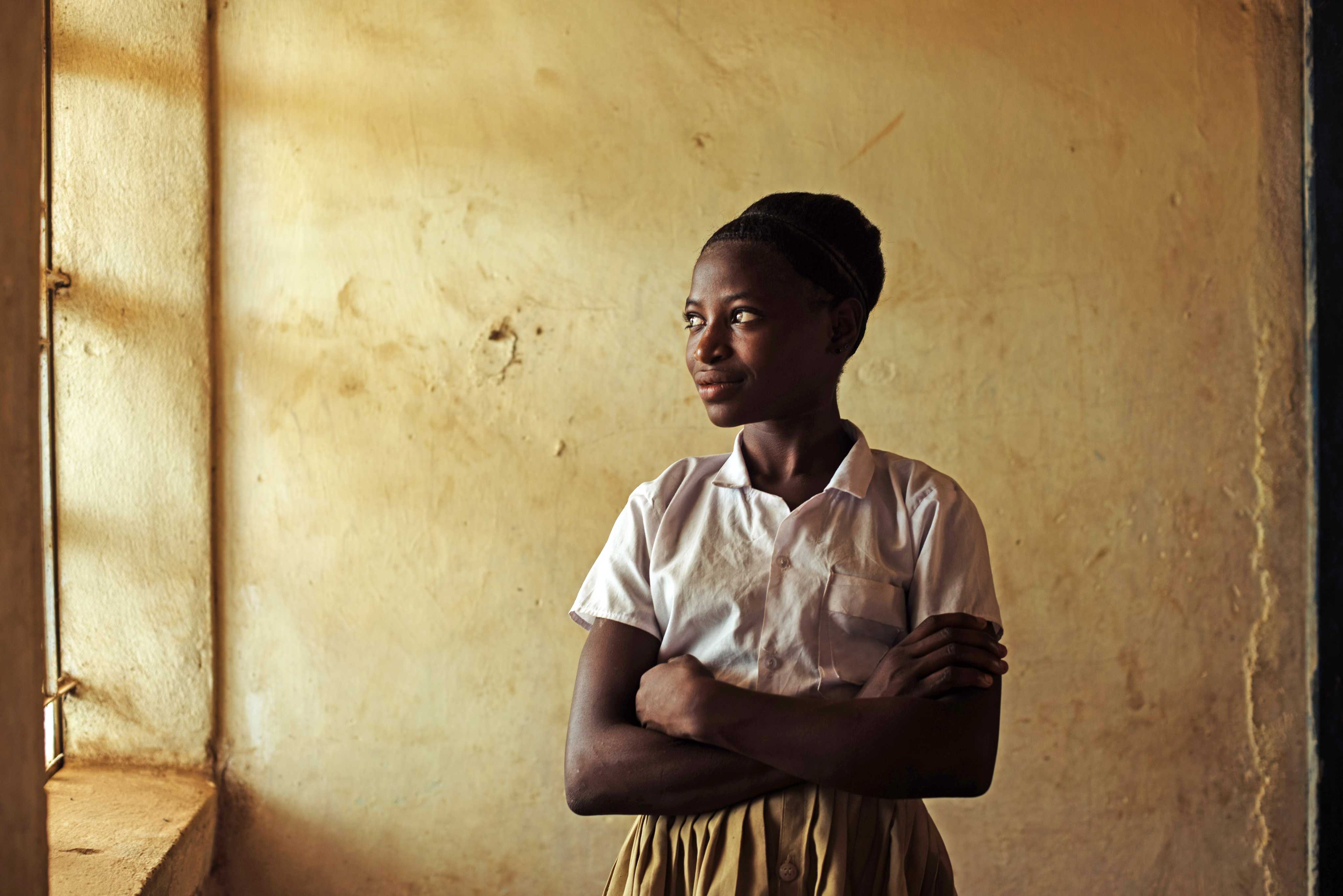 Marie, 15, staat met haar armen over elkaar. Ze voert campagne tegen gendergerelateerd geweld. 