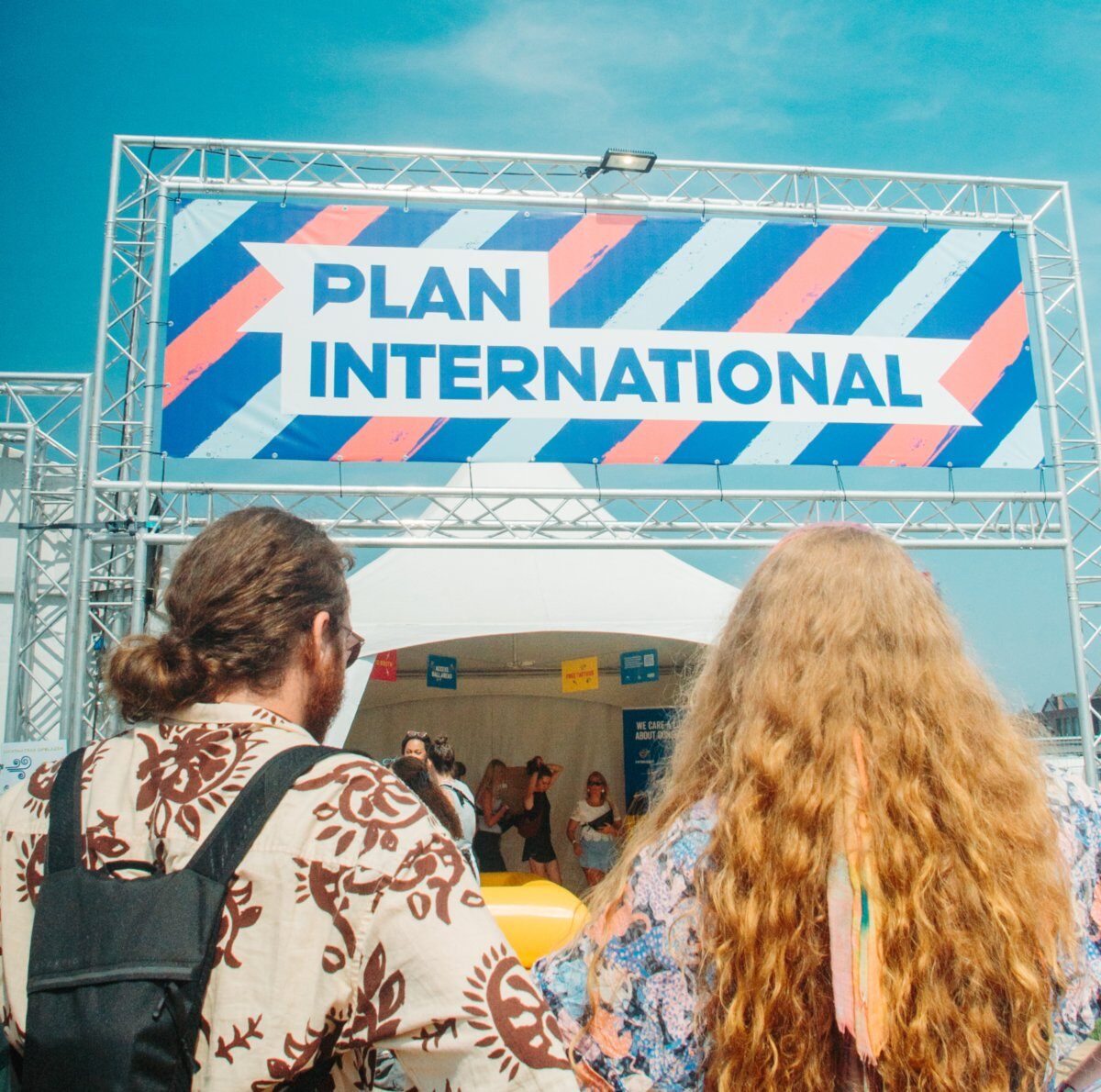 Een mannelijke en vrouwelijke festivalganger voor de #WeCare-stand van Plan International België op Pukkelpop